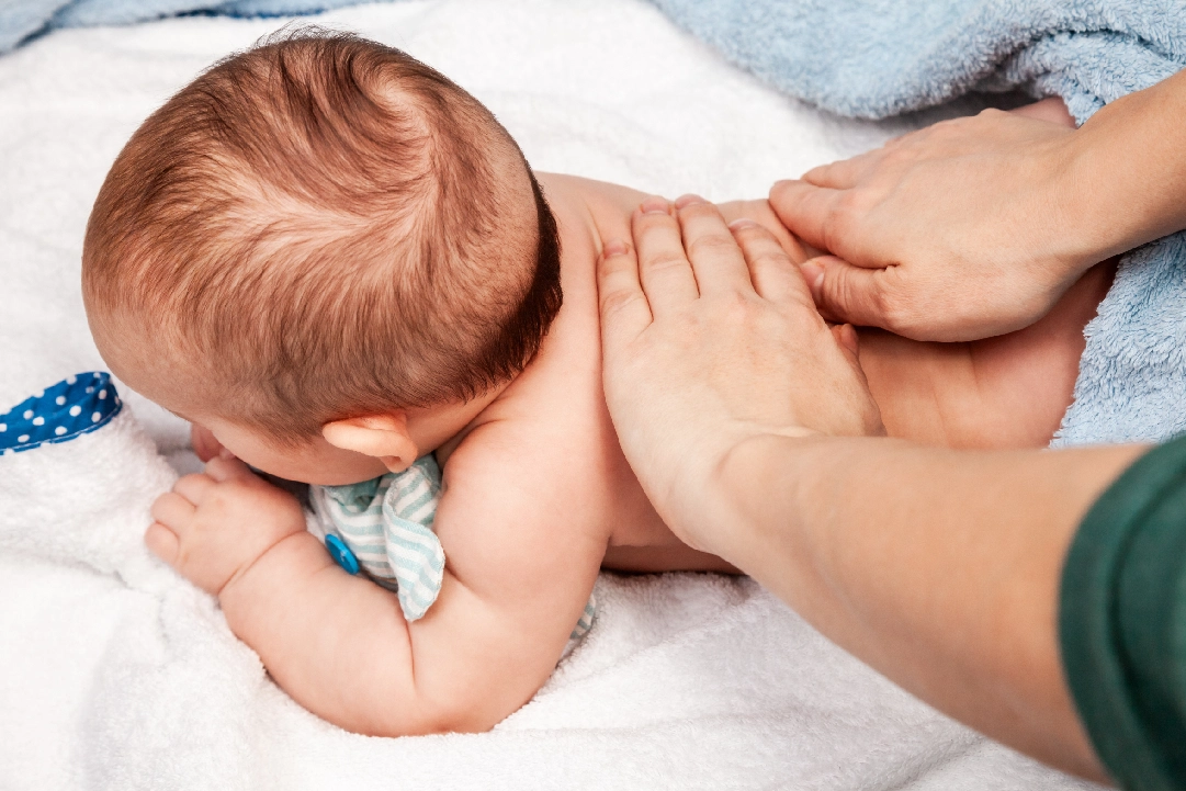 Baby getting a gentle back massage.