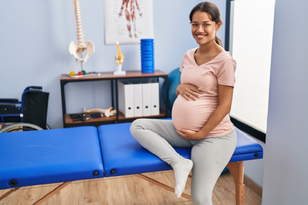 Pregnant woman smiling on a massage table.