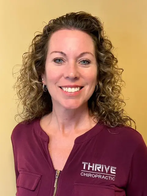 A woman with curly hair and a purple shirt